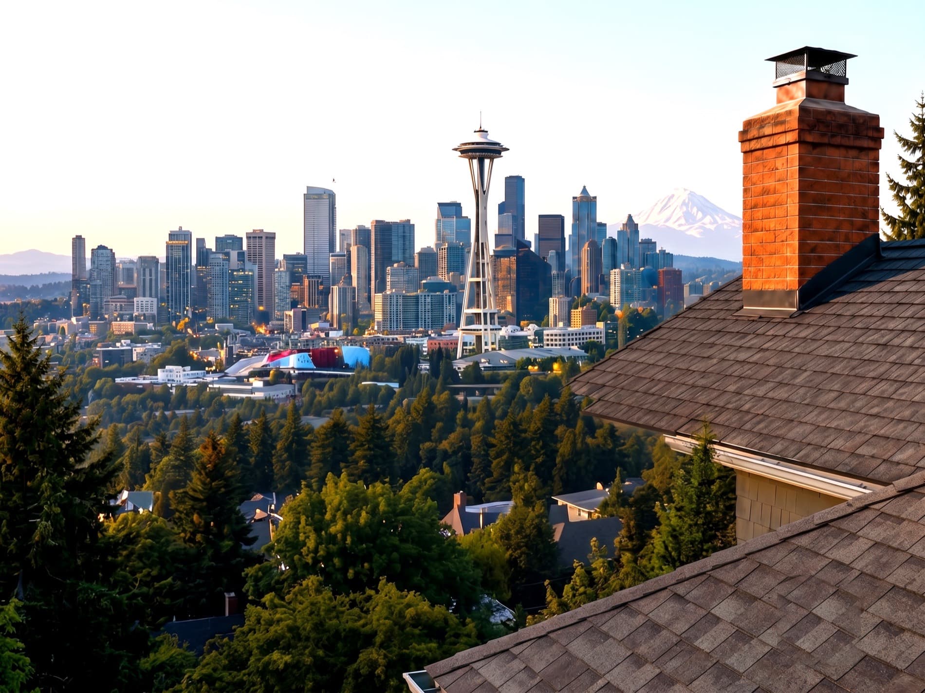 The Seattle skyline and Mount Rainier at golden hour, seen past a brick chimney on a rooftop